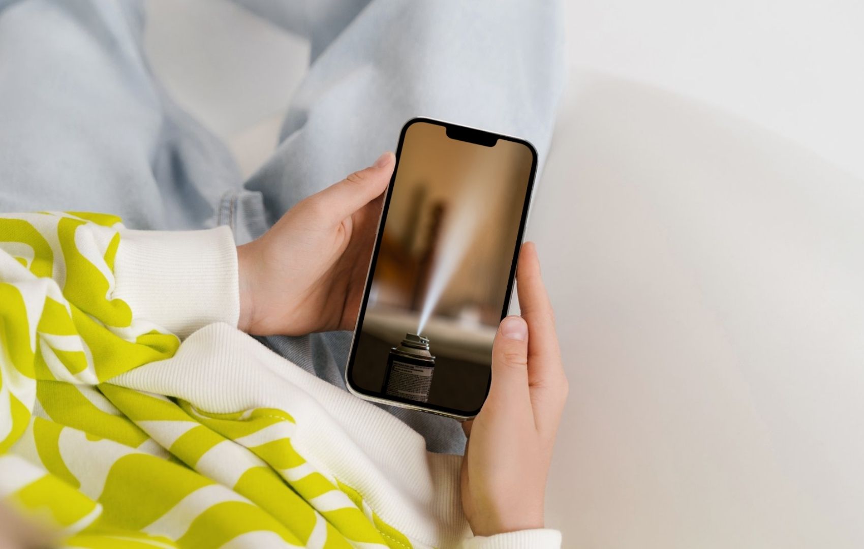 Person sitting looking at phone with fogger on it.